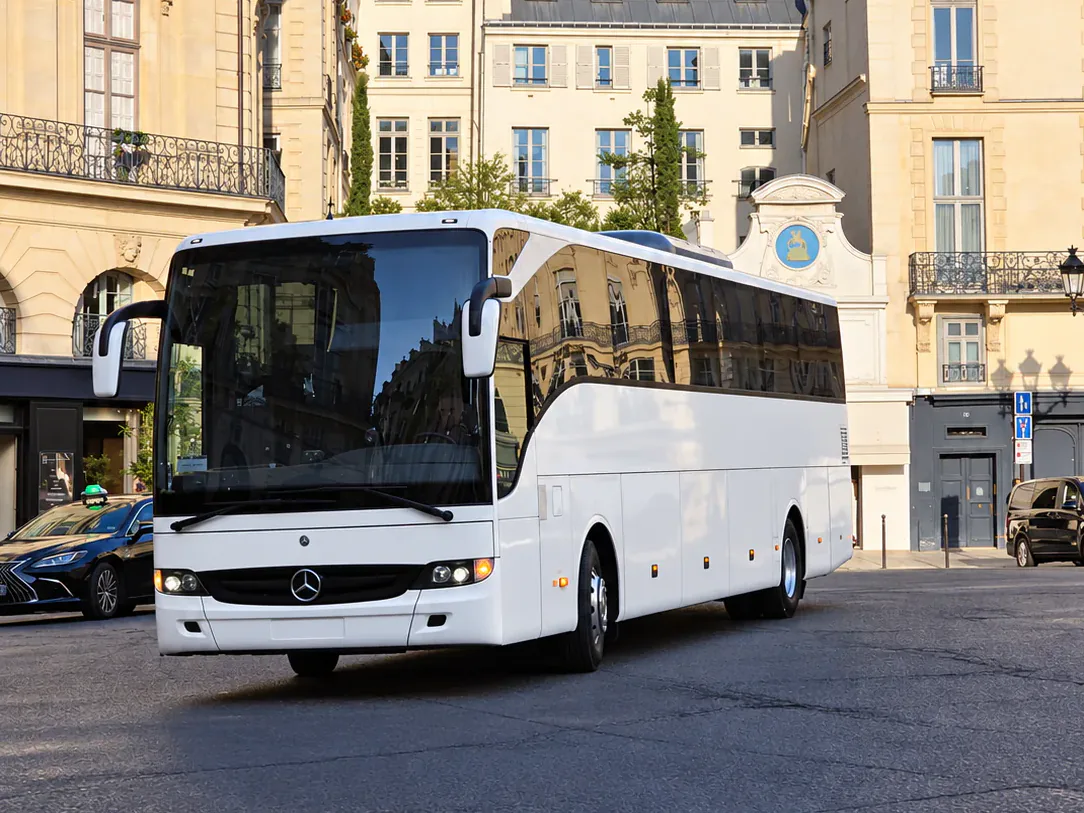 BusCom 52-seat Mercedes coach in front of Paris stone buildings