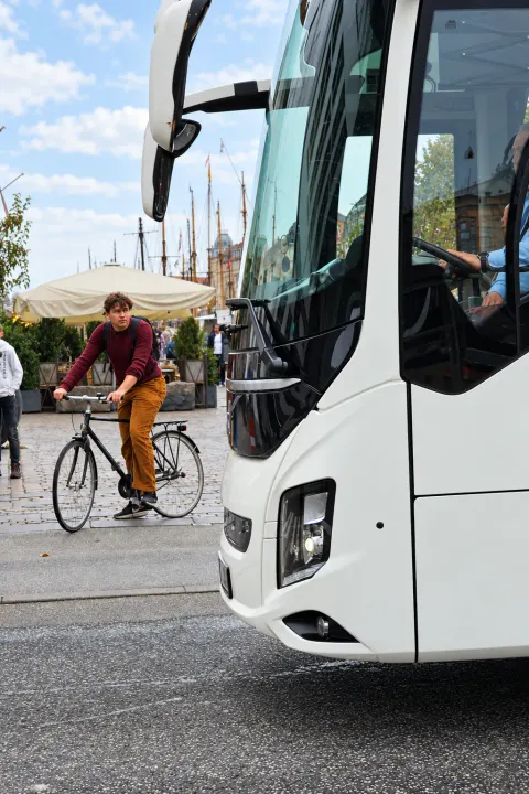 Coach on a Copenhagen square as a cyclist rides past