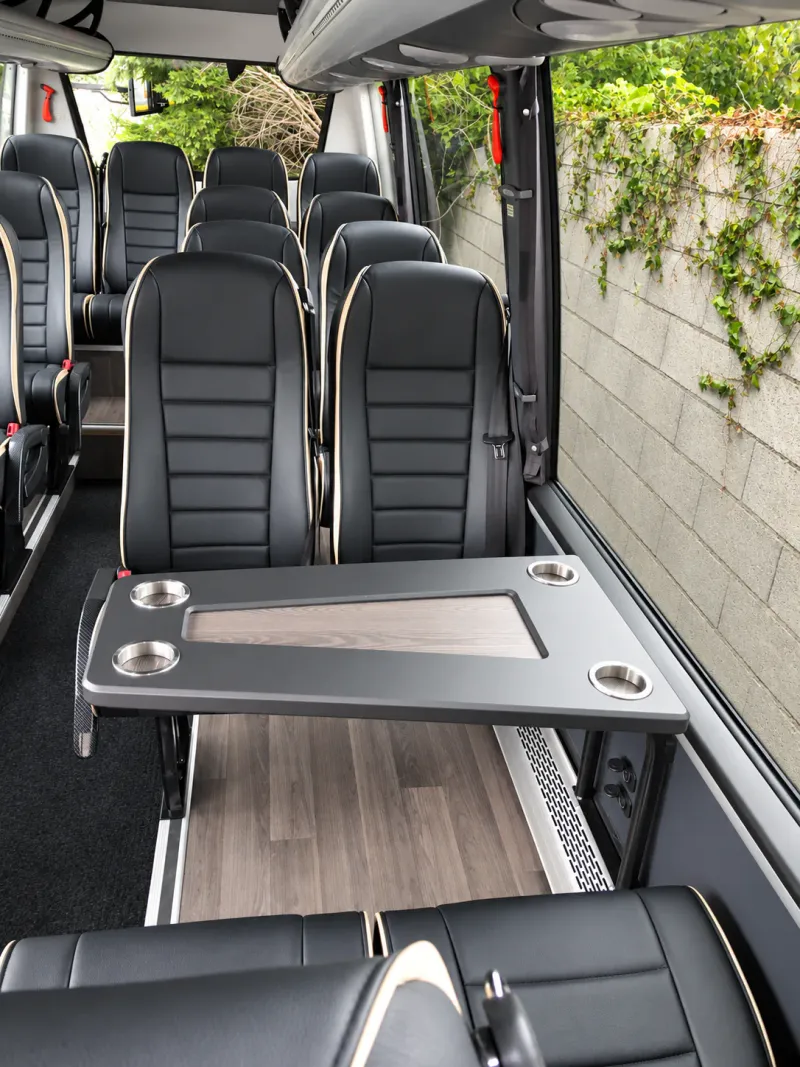 Leather seats around a table inside a BusCom 16-seat Mercedes Sprinter