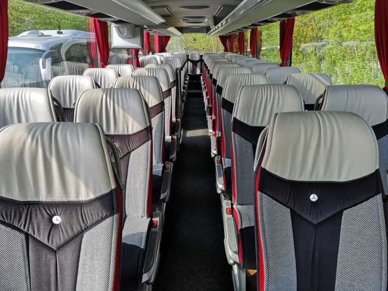 Rows of padded seats along the aisle of a coach